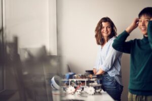 Woman and man standing near a robotics project on a desk